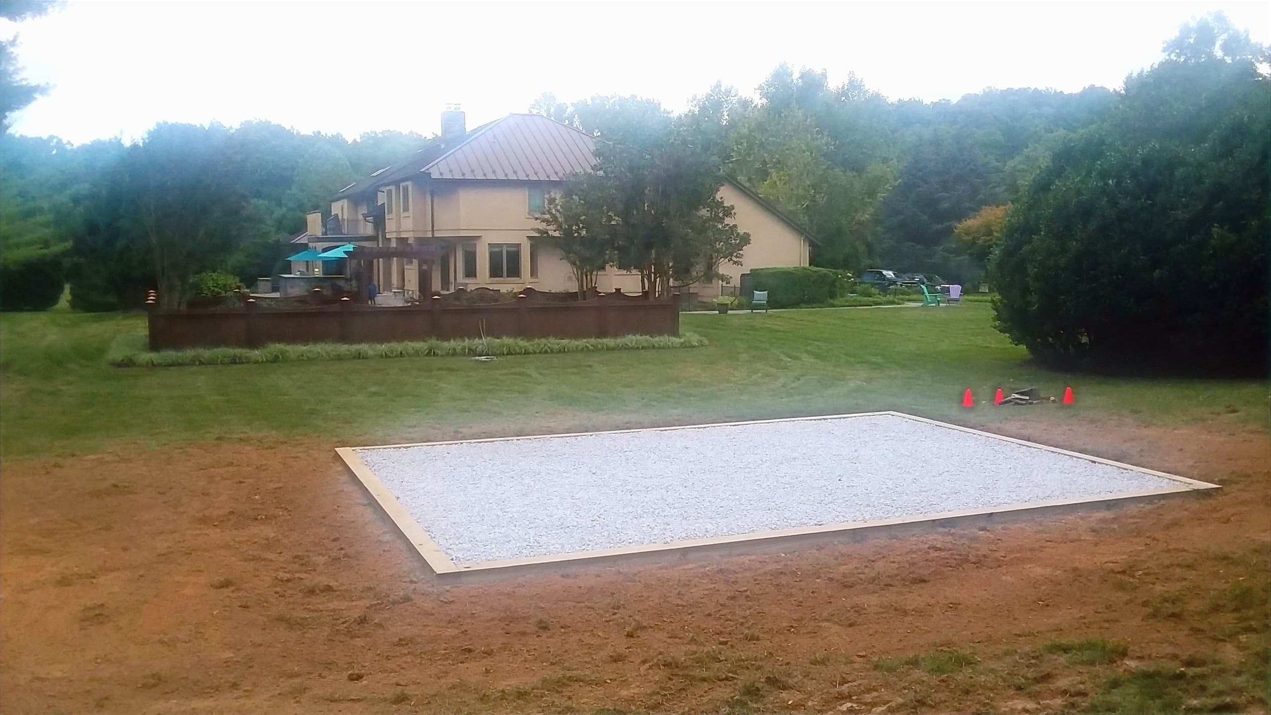 Large gravel pad foundation in front of a premium residential home