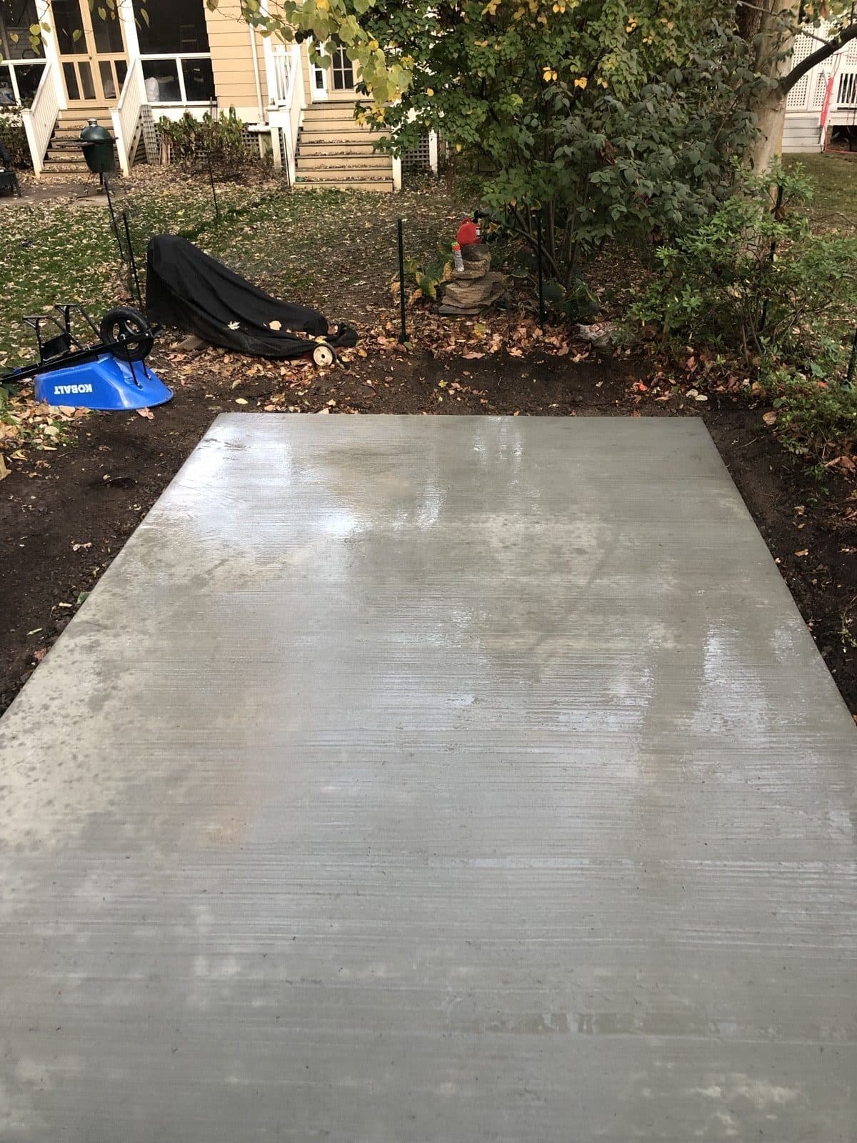 A finished 4-inch reinforced concrete slab poured in a residential backyard