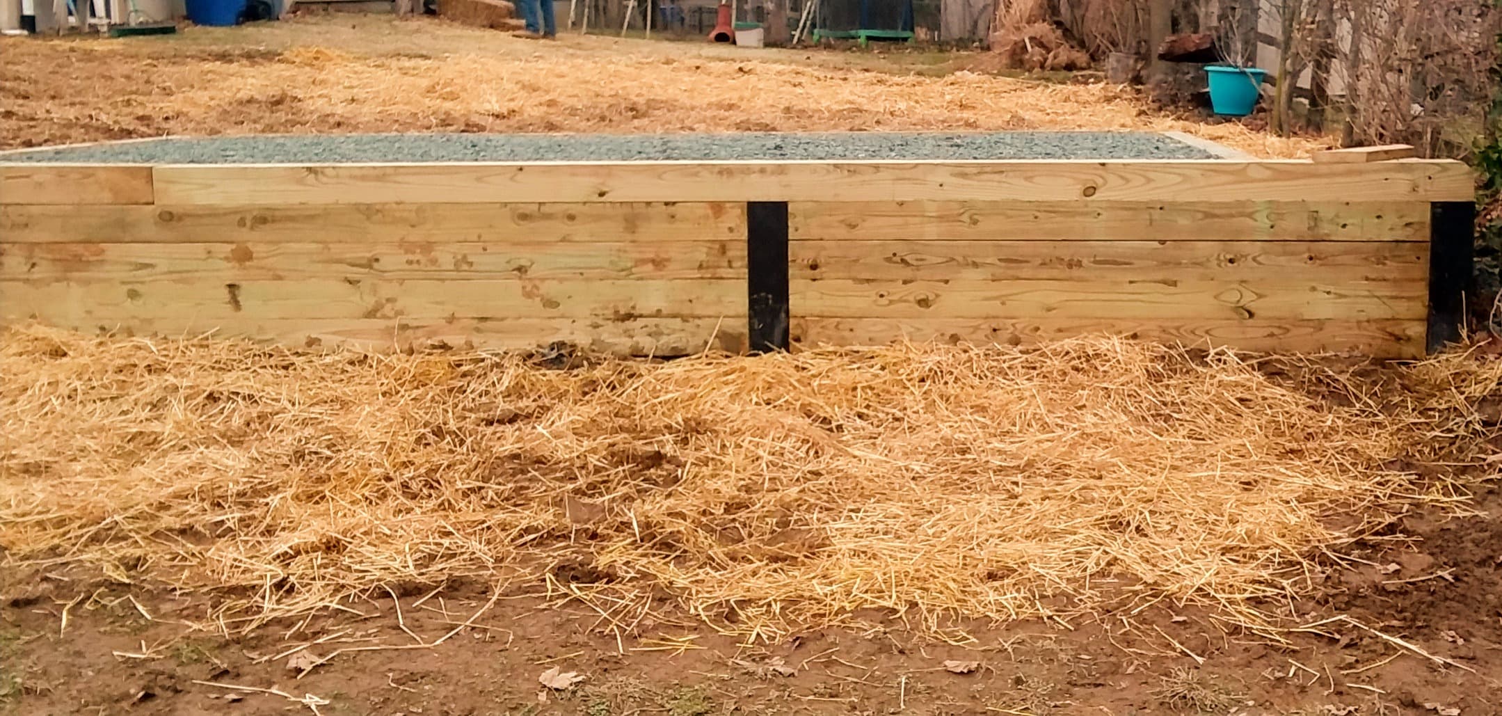 Gravel pad built up with a high retaining wall on a steep slope